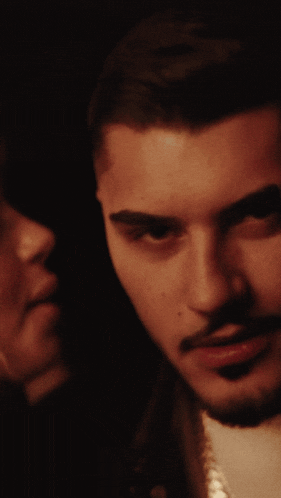 a woman kisses a man on the cheek in a close up