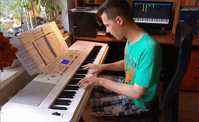 a boy in a green shirt is playing a keyboard