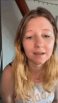 a woman with blonde hair and a nose ring is making a funny face