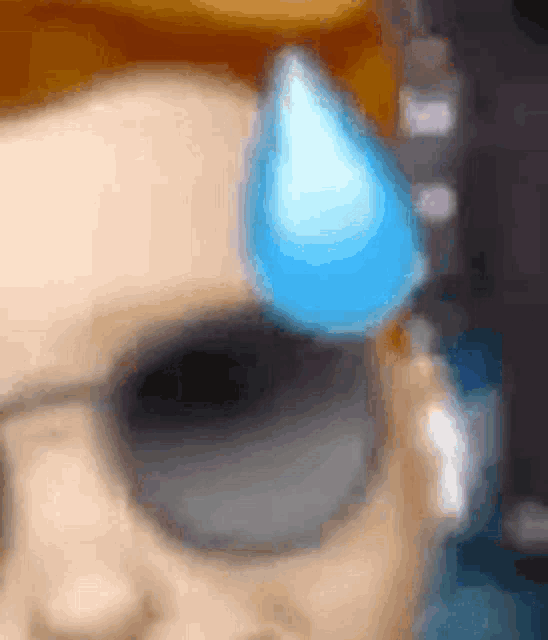 a close up of a person wearing sunglasses and ear buds with a blue tear on their forehead .