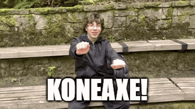 a young man is sitting on a wooden bench with the words koneaxe written above him .