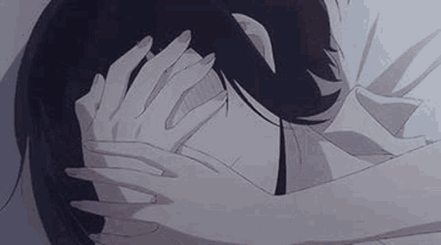 a woman is covering her face with her hands while a man holds her head .