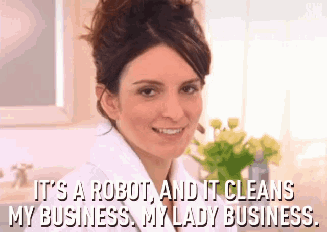 a woman in a white robe is smiling and saying it 's a robot and it cleans my business .