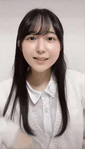 a young woman with long black hair is wearing a white shirt and white jacket .