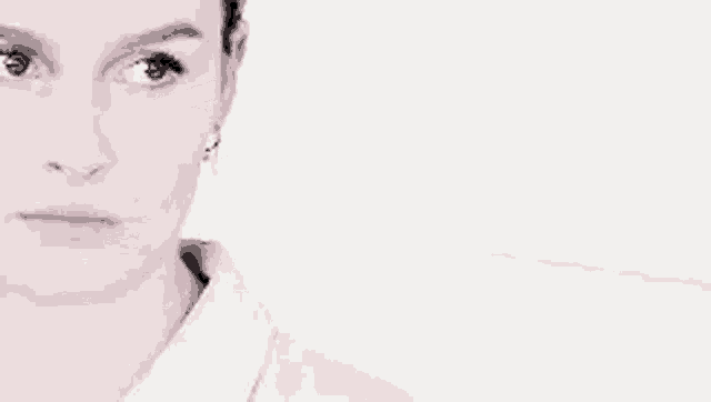a close up of a woman 's face with a white background and a serious look on her face .