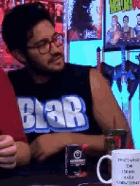 a man wearing glasses and a black shirt that says blah