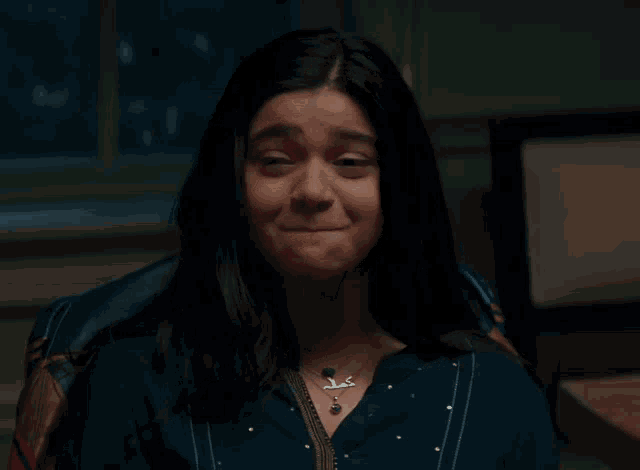 a woman wearing a necklace that says ' a ' on it