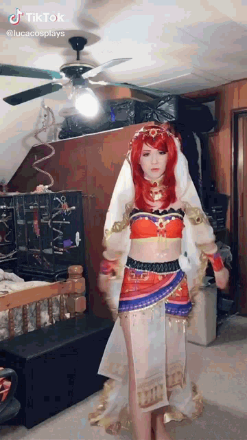 a woman in a costume is standing in a room with a ceiling fan and a bed .