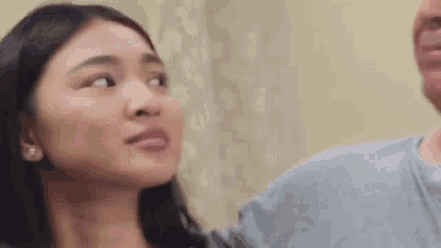 a man and a woman are standing next to each other in a room .