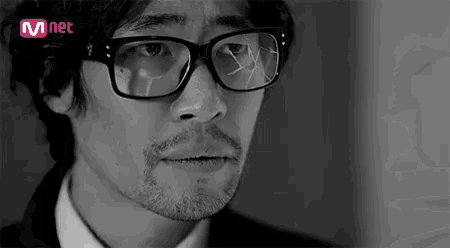 a man with a beard wearing glasses and a suit is crying .