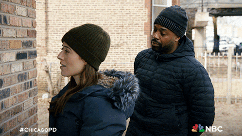 a man and a woman are standing next to each other in front of a brick wall with #chicagopd on the bottom right