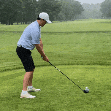 a man is swinging a golf club on a green