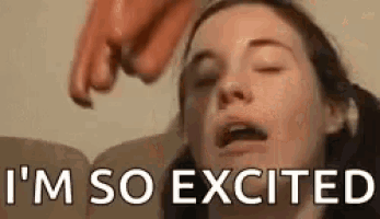 a woman is sitting on a couch with her eyes closed while a sausage is being thrown at her face .