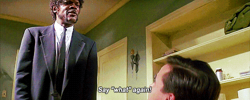 a man in a suit and tie is talking to another man in a room and says " say " what " again "