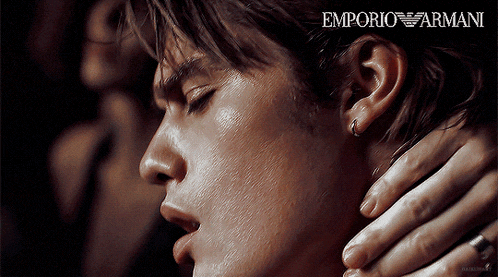 a close up of a man 's face with emporio armani written on the bottom right