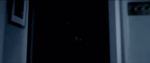 a ghost is coming out of a dark room in a dark room .
