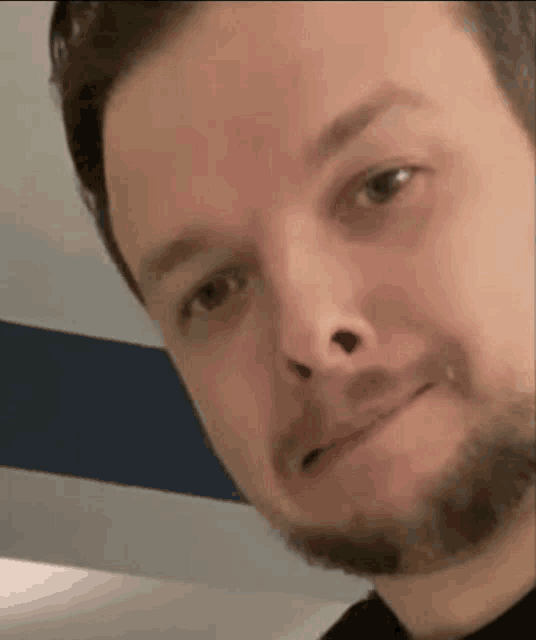 a close up of a man 's face with a beard making a funny face .