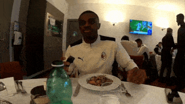 a man sitting at a table with a plate of food in front of him
