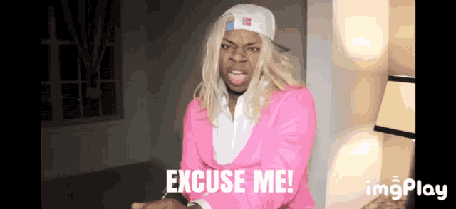a man in a pink jacket and white hat says excuse me !
