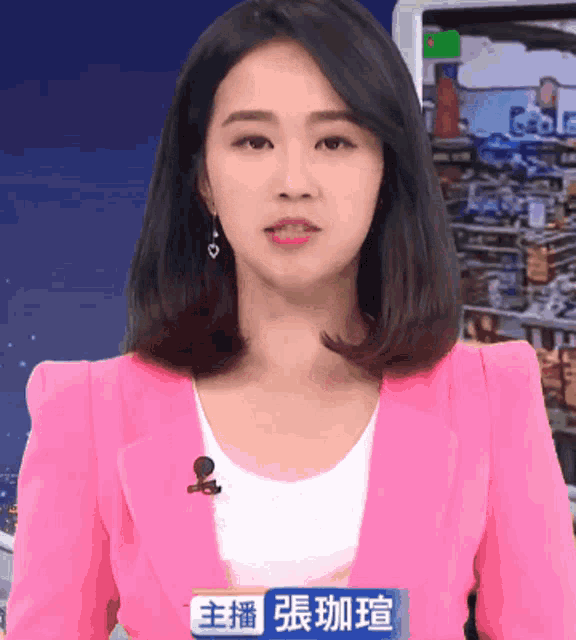 a woman in a pink jacket with a microphone on her neck