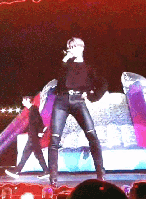 a man is singing into a microphone on stage
