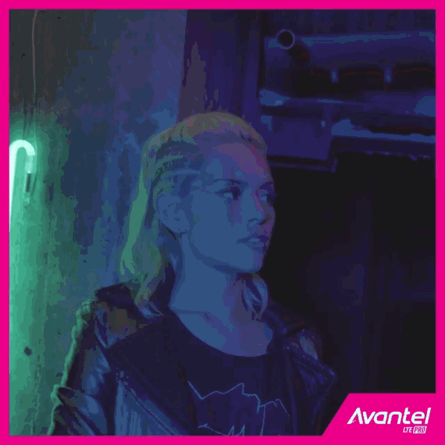 a woman is smiling in front of a neon sign that says avantel on it