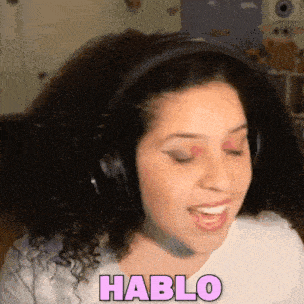a woman wearing headphones is smiling and says hablo