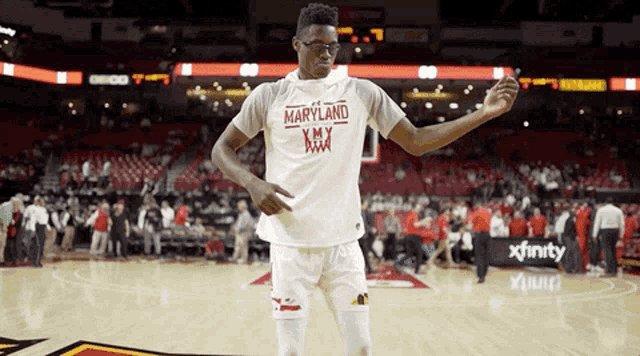a basketball player wearing a maryland jersey stands on the court