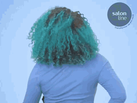 a woman with blue hair is wearing a blue shirt