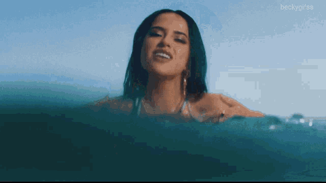 a woman in a bikini is swimming in the ocean with the hashtag beckygifss below her