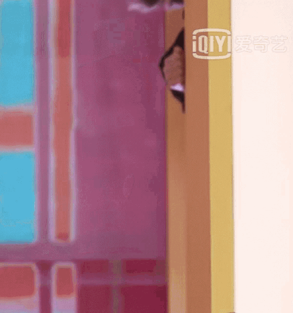 a person is peeking out from behind a wall with a sign that says ' iqyi ' on it