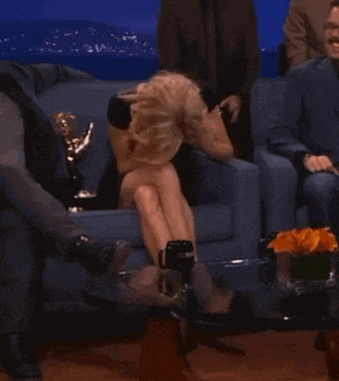 a woman sits on a couch with her legs crossed