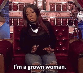 a woman is sitting on a couch and saying i 'm a grown woman