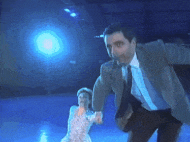a man in a suit is holding a woman in a dress