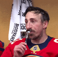 a man in a red jersey is eating a piece of food