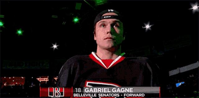 a hockey player named gabriel gagne is standing in a dark room
