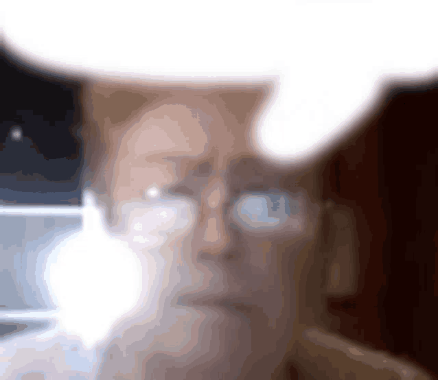 a close up of a person 's face with glasses and a speech bubble .