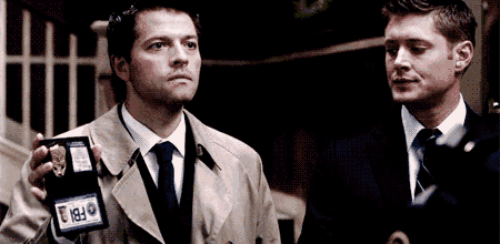 two men are standing next to each other and one has a fbi badge on his sleeve
