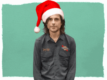 a man wearing a santa hat is wearing a shirt that says garage