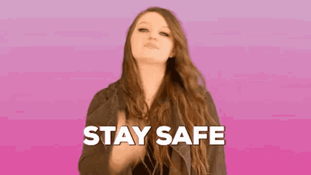 a woman with long hair is giving a thumbs up with the words stay safe behind her .