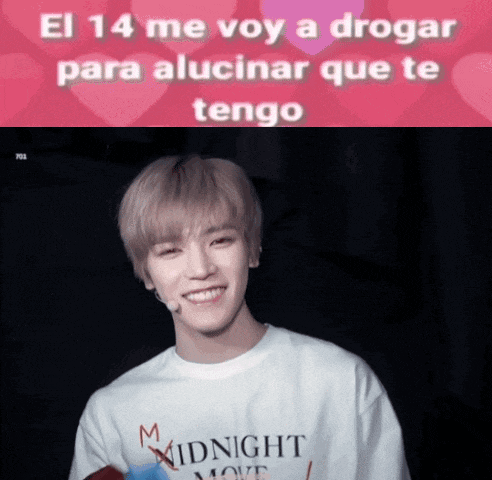 a man wearing a midnight move shirt smiles in front of a pink background