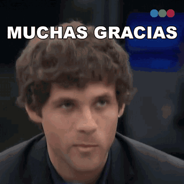 a man in a suit says muchas gracias in front of a blue background