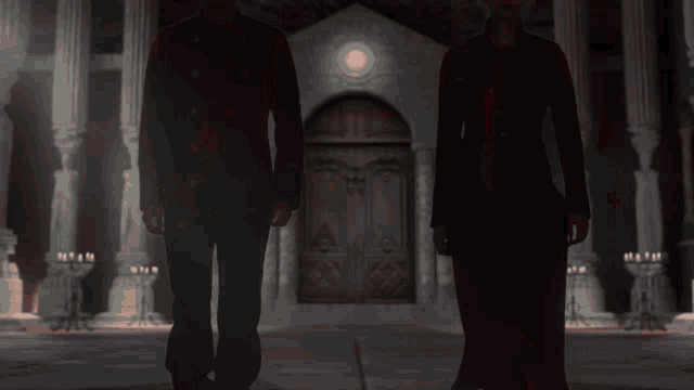 a man and a woman walking in a dark room