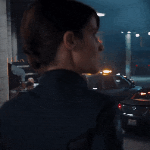 a woman wearing a black jacket with a shield on the sleeve