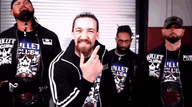 a group of men wearing bullet club shirts stand together
