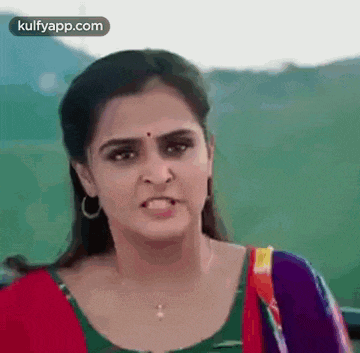 a woman is making a funny face while wearing a necklace .