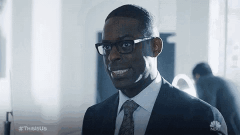 a man in a suit and tie is smiling while standing in a room .