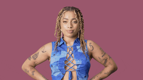 a woman is standing in front of a pink background with the words yeah b * tch