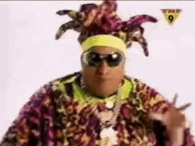 a man wearing sunglasses and a clown hat is dancing .