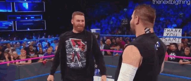 two men hugging each other in a wrestling ring .